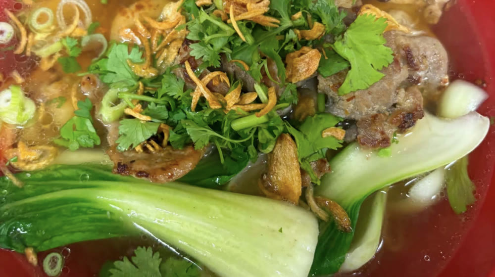 Noodle soup with grilled pork, bok choy, coriander and fried shallots