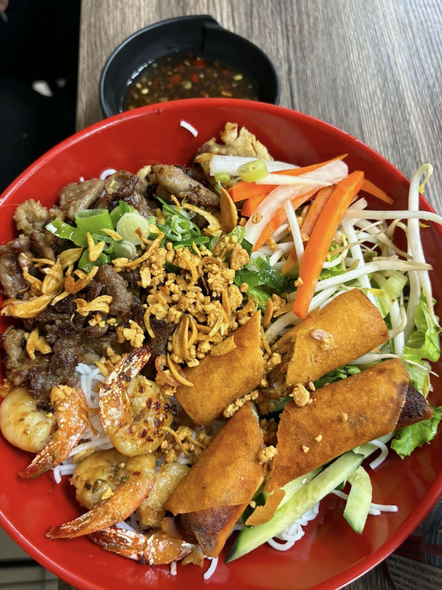 A vermicelli bowl with grilled pork, shrimp, spring rolls, pickled vegetables and bean sprouts